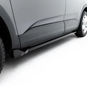 Close-up of a gray car's side panel and front wheel, showing body lines and tire tread