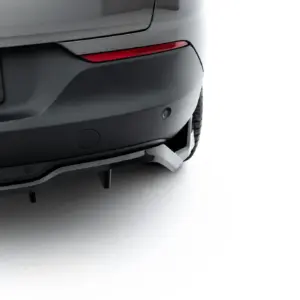 Rear view of a dark SUV showing a red tail light, bumper, and part of a license plate with white text on black background (car on left, white background on right).