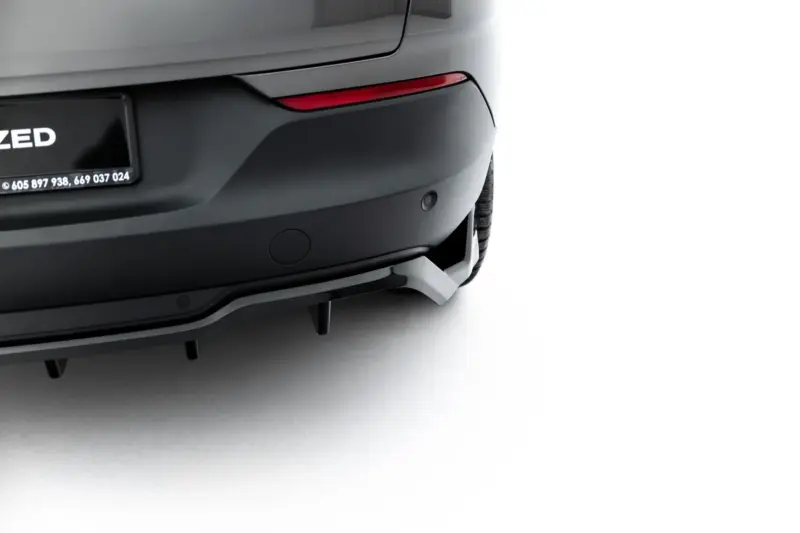 Rear view of a dark SUV showing a red tail light, bumper, and part of a license plate with white text on black background (car on left, white background on right).