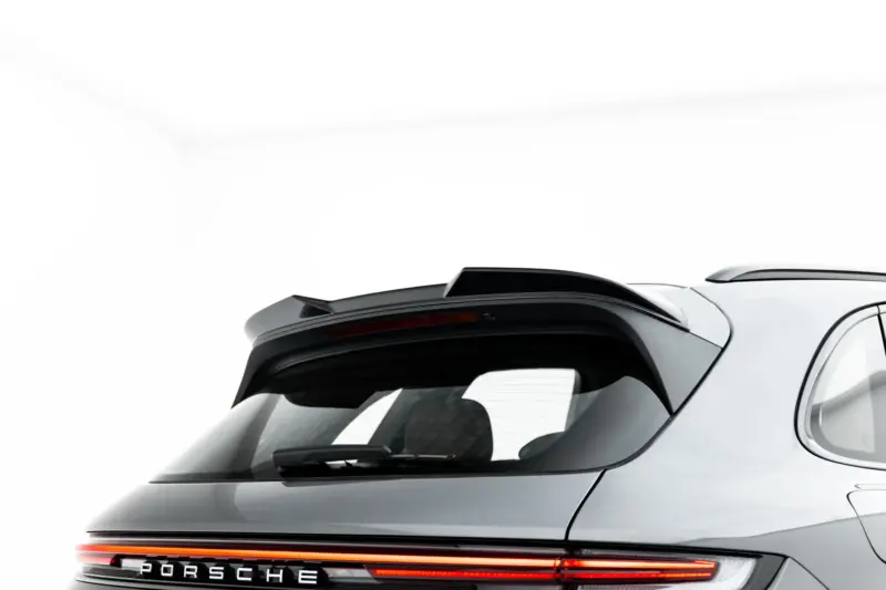 pol_po_Set-of-Splitters-Porsche-Cayenne-SUV-Mk3-Facelift-23886_15webp - OPSHOLDERS Partial rear view of a silver Porsche SUV, showing the back window, spoiler, and a full-width red taillight strip with PORSCHE lettering behind.