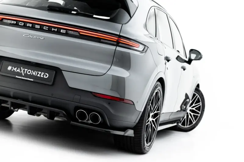 pol_po_Set-of-Splitters-Porsche-Cayenne-SUV-Mk3-Facelift-23886_9webp - OPSHOLDERS Rear view of a silver Porsche Cayenne with illuminated horizontal tail lights and distinctive badging, showing dual exhausts and large alloy wheels at an angle.
