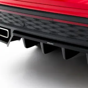 Close-up of a red car front bumper with a black honeycomb grille and Maxton Design badge.