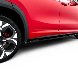 Close-up of a red car's side body and large alloy wheel with black-and-silver spokes against a white background.