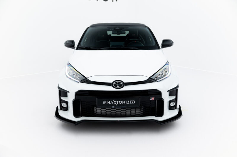 Front view of a white Toyota SUV in a studio, showing black grille and '#MAXTONIZED' license plate area at center