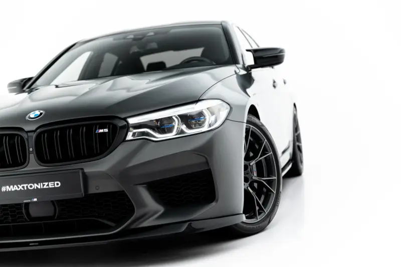 pol_po_Set-of-Splitters-V-1-BMW-M5-F90-23925_1webp - OPSHOLDERS Front-left view of a gray BMW M5 with a prominent kidney grille and '#MAXTONIZED' plate on a white background