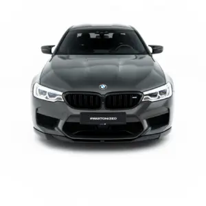 Front view of a gray BMW M5, headlights on, black kidney grille, against a white background with #MAXTONIZED on the license plate area