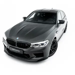 Front three-quarter view of a dark gray BMW sedan with sporty wheels on a white studio background, showing the kidney grille and LED headlights.