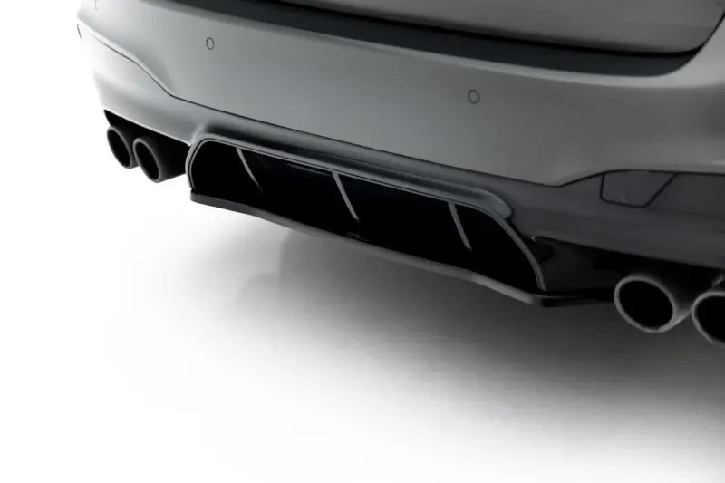 pol_po_Set-of-Splitters-V-1-BMW-M5-F90-23925_13webp - OPSHOLDERS Close-up of a car's rear bumper showing dual exhaust pipes with a sleek chrome finish on a white background