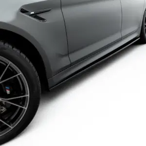 Close-up of a gray BMW car's front-left side, featuring a large black alloy wheel, brake rotor, and a side vent with M badge