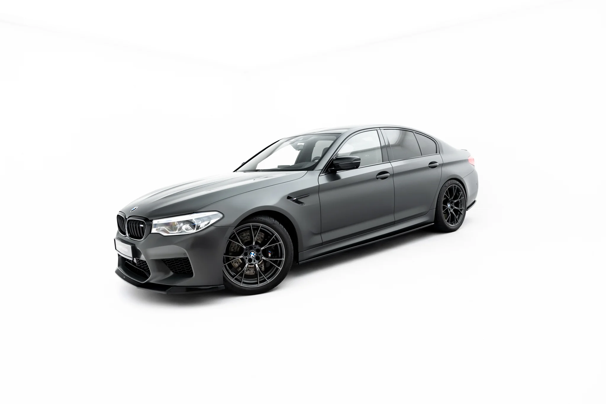 pol_po_Set-of-Splitters-V-1-BMW-M5-F90-23925_3webp - OPSHOLDERS Gray BMW sedan shown from a front-left angle with black alloy wheels on a white background