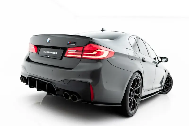 pol_po_Set-of-Splitters-V-1-BMW-M5-F90-23925_6webp - OPSHOLDERS Rear three-quarter view of a gray BMW M5 Competition with a spoiler, illuminated taillights, and quad exhausts on a white backdrop (#MAXTONIZED).