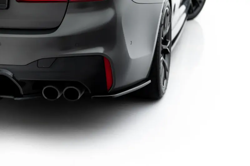 pol_po_Set-of-Splitters-V-1-BMW-M5-F90-23925_7webp - OPSHOLDERS Close-up of the rear quarter panel of a dark gray sports car, showing its dual exhausts and rear bumper details.