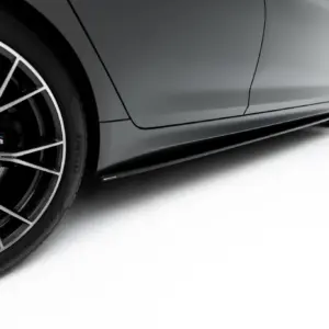 Close-up of a silver BMW sports car showing a large multi-spoke alloy wheel, brake disc, and gray body panel with the M badge visible on the brake caliper area.
