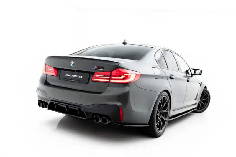 pol_po_Set-of-Splitters-V-1-BMW-M5-F90-23925_9webp - OPSHOLDERS Rear view of a gray BMW M3 Competition with a '#MAXTONIZED' license plate, showcasing quad exhausts and red taillights on a white backdrop.