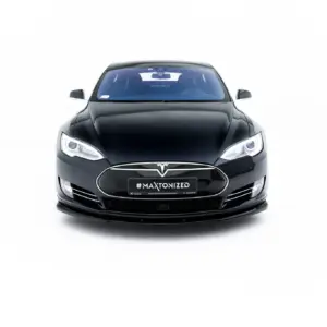 Front view of a black Tesla car facing the camera, with '#MAXTONIZED' on the license plate area and prominent headlights.