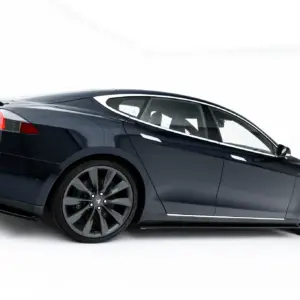 Rear-left side view of a dark blue Tesla Model S in a studio setting, highlighting the rear lights and aerodynamic bodywork.