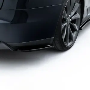 Close-up of a dark Tesla Model S rear quarter panel showing the P85D badge and rear wheel.