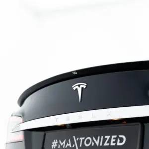 Rear of a white Tesla SUV showing the chrome Tesla emblem and the hashtag #MAXTONIZED on the license plate area.