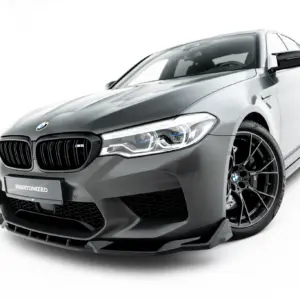 Front-left view of a silver BMW M5 sports sedan against a white background, highlighting the bold kidney grille and sharp headlights.