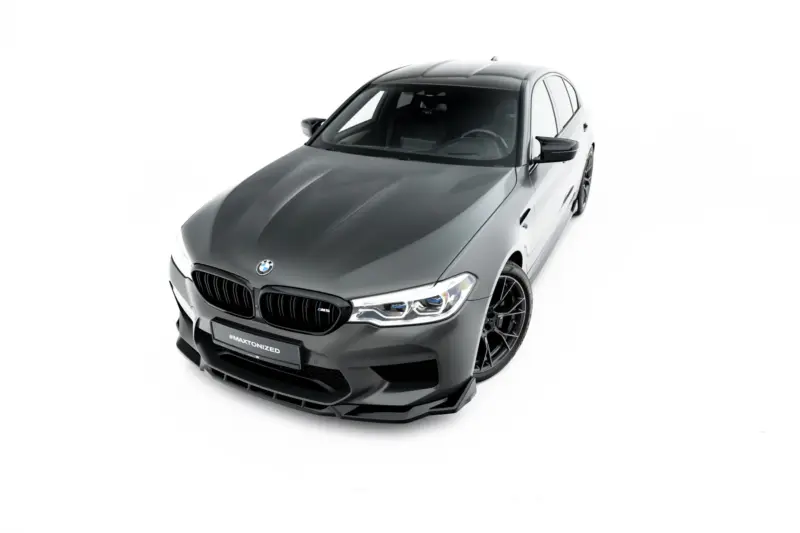 pol_po_Set-of-Splitters-V-2-BMW-M5-F90-23926_12webp - OPSHOLDERS High-angle view of a silver BMW M sporty car facing left, showcasing front grille and aggressive styling.