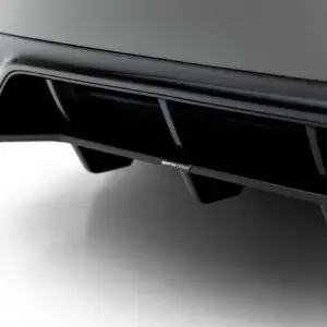 Close-up of a car rear bumper with dual exhaust tips and a Maxton Design badge.