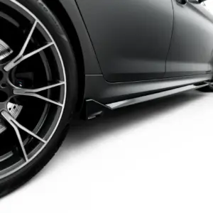 Close-up of a sleek BMW wheel and lower side panel of a sports car, highlighting the rim and brake details