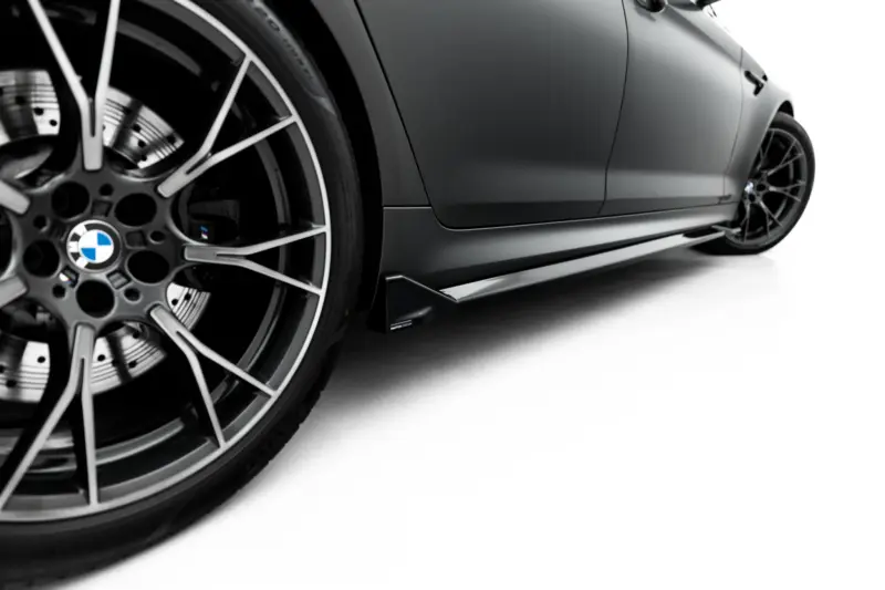 pol_po_Set-of-Splitters-V-2-BMW-M5-F90-23926_4webp - OPSHOLDERS Close-up of a sleek BMW wheel and lower side panel of a sports car, highlighting the rim and brake details