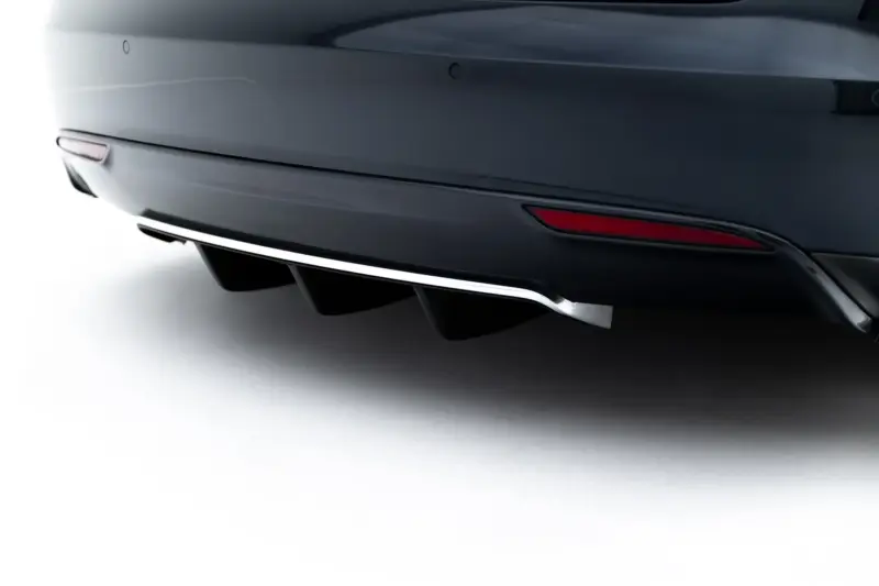 Close-up of a sleek car's rear bumper with a chrome exhaust fin and red reflector in a dark metallic finish.