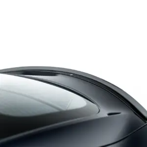 Close-up of a glossy black car hood and windshield, showing smooth aerodynamic curves in soft lighting.