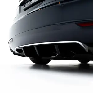 Close-up of the rear end of a dark, glossy car showing the bumper, exhaust tip, and taillight across a white background.