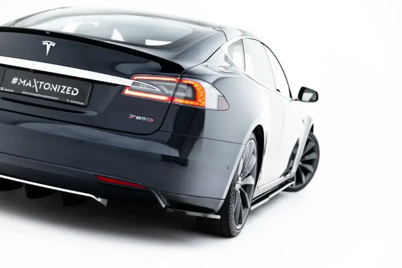 Rear view of a dark Tesla Model S showing taillights and a black license plate reading '#MAXTONIZED' on a white background.