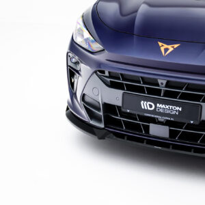 Close-up of a dark blue car's front end, featuring a headlight, glossy hood, and orange emblem on the hood.