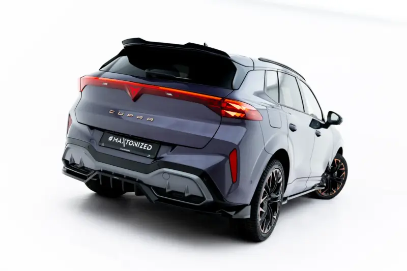 Rear three-quarter view of a dark gray CUPRA SUV with illuminated taillight on a white studio background.