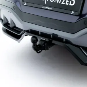 Close-up of a vehicle's rear with a tow hitch ball and mounting hardware visible under the bumper.