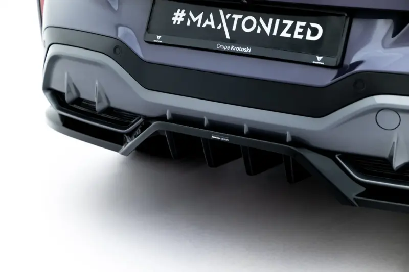 Close-up of a car's rear bumper and license plate displaying '#MAXTONIZED' with branding text underneath (Grupa Krotoski).