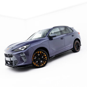 Front three-quarter view of a metallic purple SUV with orange-accent wheels in a white studio backdrop.