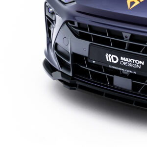 Close-up of the front end of a dark blue car showing the grille, bumper, and Maxton Design plate logo on the license area.