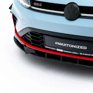 Front of a light-blue Volkswagen with VW emblem, GLI badge, black grille, and red trim at the bumper nearby a license plate reading #MAXTONIZED.