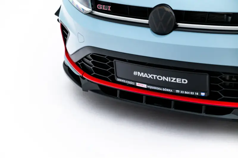 Front of a light-blue Volkswagen with VW emblem, GLI badge, black grille, and red trim at the bumper nearby a license plate reading #MAXTONIZED.