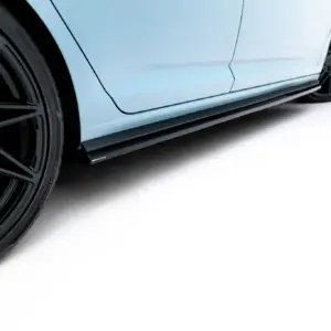 Close-up of a blue car's side with a large black alloy wheel and red brake calipers visible at the edge of the frame.