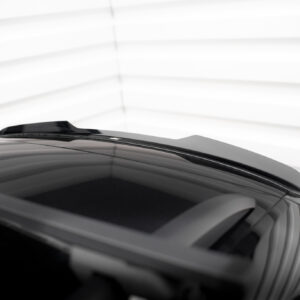 Close-up of a dark car roof and rear window with reflections, set against a bright, blurred backdrop of horizontal blinds