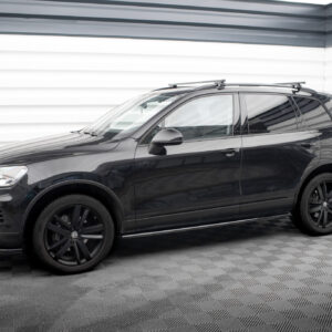 Black SUV with roof rack, photographed from the front-left side in a studio setting.