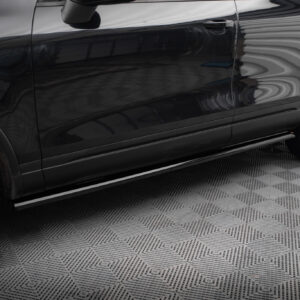 Side view of a black SUV door with reflection, including mirror and wheel nearby.