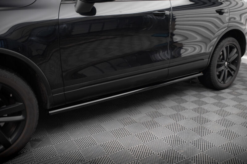 Side view of a black SUV door with reflection, including mirror and wheel nearby.