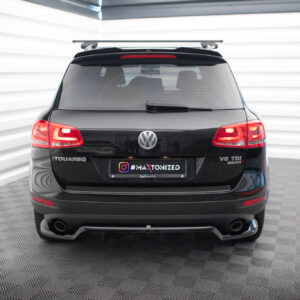 Rear view of a black Volkswagen Touareg SUV with a roof rack, parked in a bright studio setting