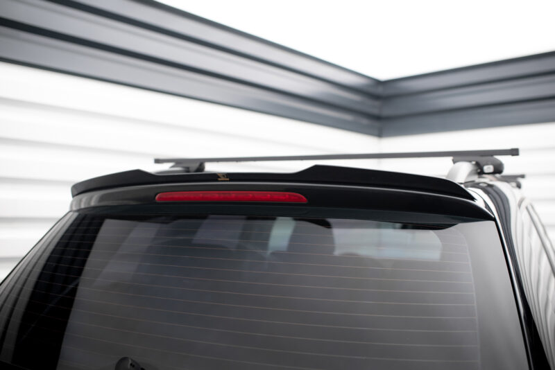 Rear view of a dark SUV with a roof rack crossbars mounted on top, above the rear window.