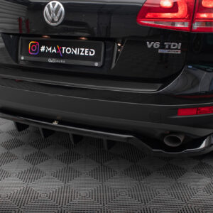 Rear view of a black Volkswagen Touareg with a custom license plate reading '#MAXTONIZED' and the 'V6 TDI' badge in a showroom setting.
