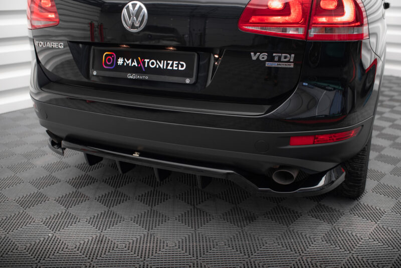 Rear view of a black Volkswagen Touareg with a custom license plate reading '#MAXTONIZED' and the 'V6 TDI' badge in a showroom setting.