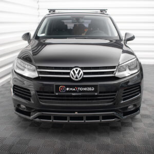 Front view of a black Volkswagen SUV with a roof rack, parked in a white panel backdrop; license plate reads '#MAXTONIZED'