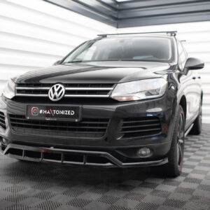 Front three-quarter view of a black Volkswagen SUV in a bright studio, chrome grille, and a '#MAXTONIZED' license plate visible at the front.